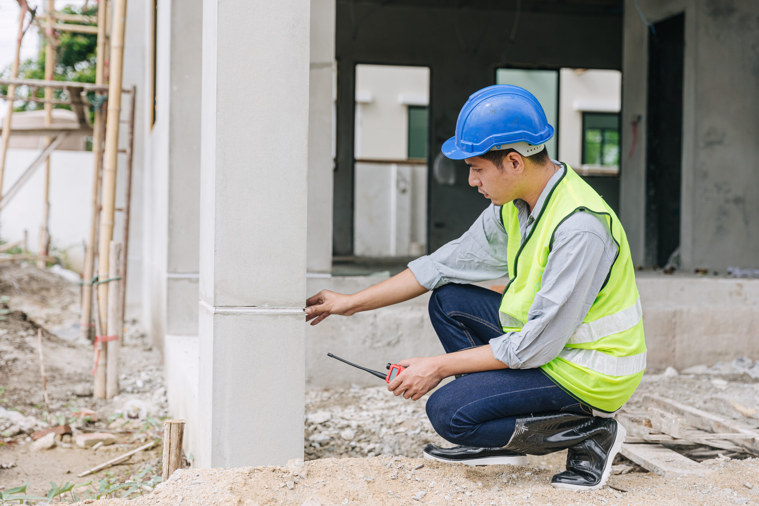 engineer foreman working checking detail of home building pillars build quality at construction site